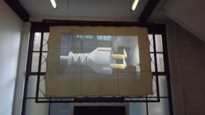 An image of an electrical plug projected image onto a screen that is attached to a metal frame.