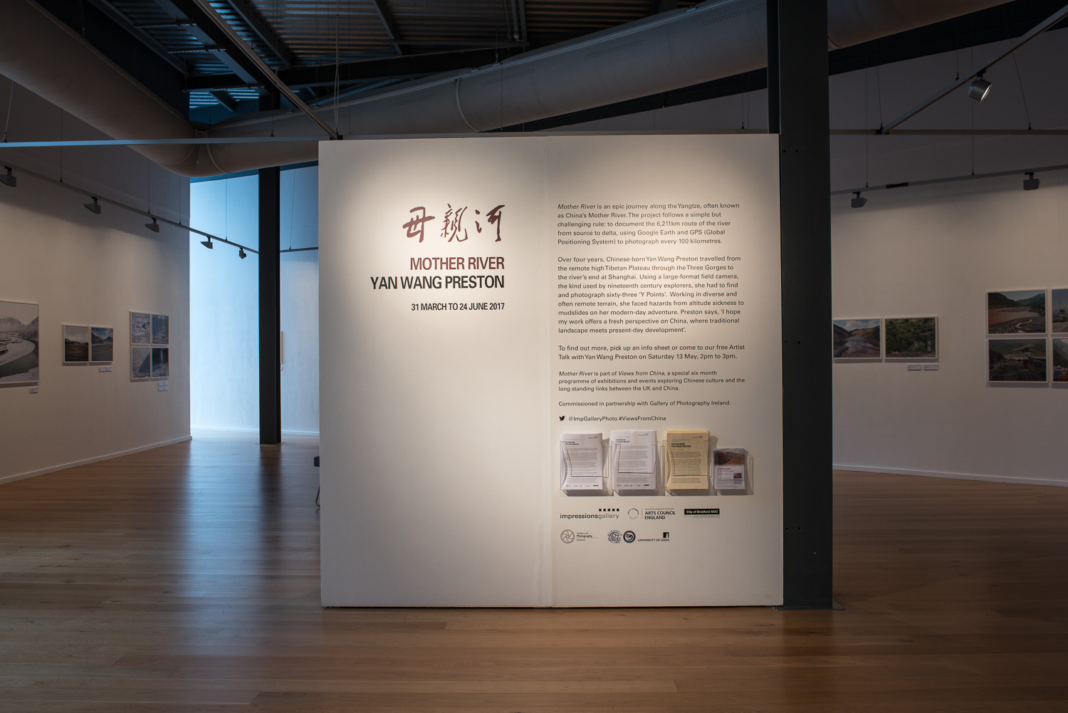 A wall in a gallery with exhibition text and resources.