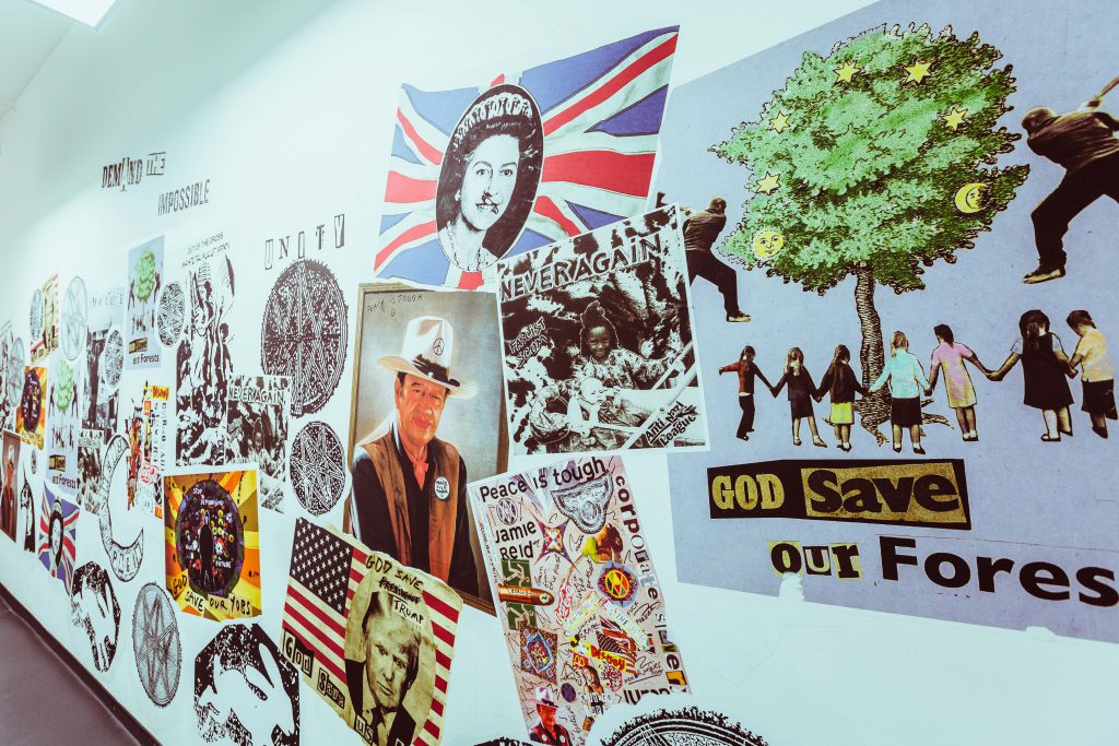 A gallery wall featuring a number of wheatpasted posters referring to British history and culture.