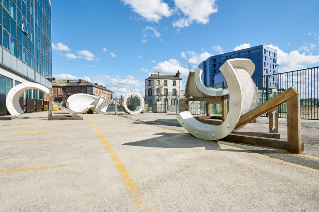 A selection of large sculptures positioned outdoors in an urban environment.