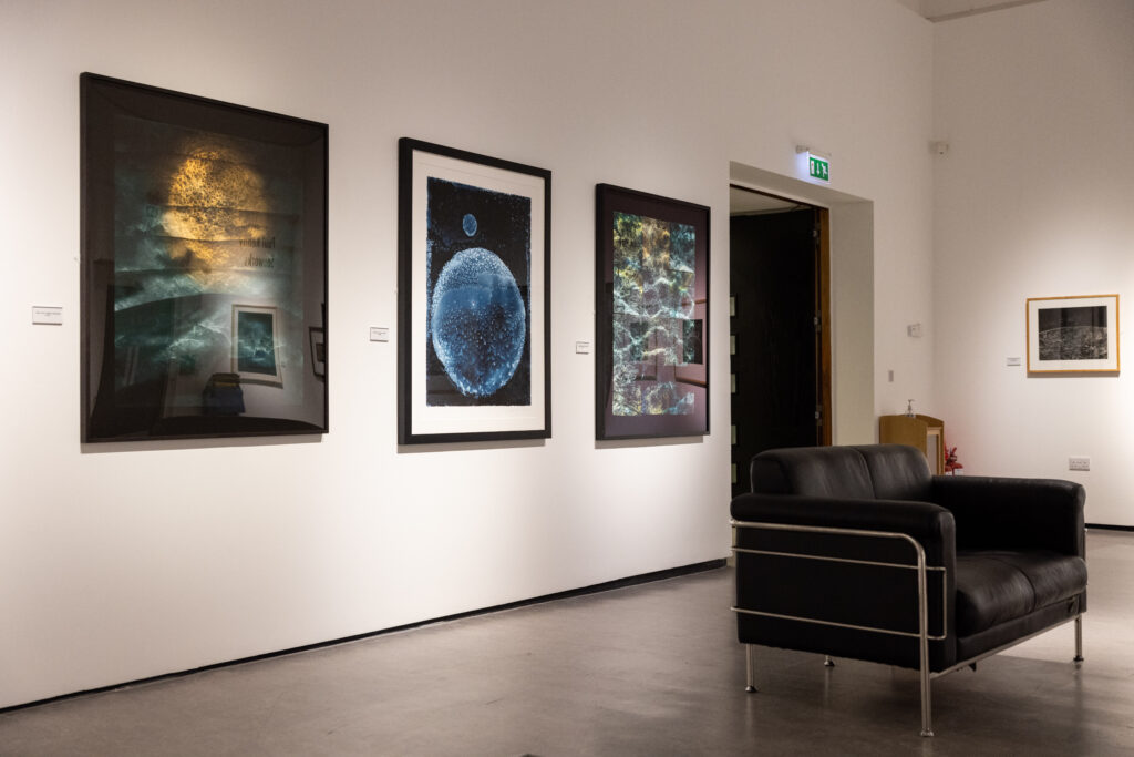 An installation of shot of the exhibition featuring a three large framed photographs by Paul Kenny