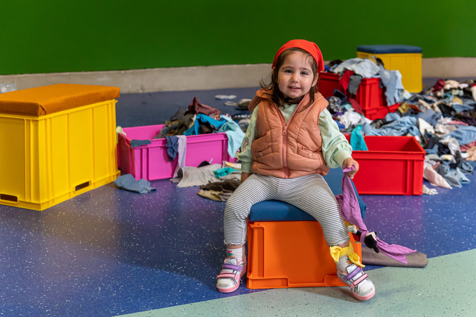 Photograph of child sitting on box in the installation ‘The Seeing Hands’ (2022) by Katie Schwab.