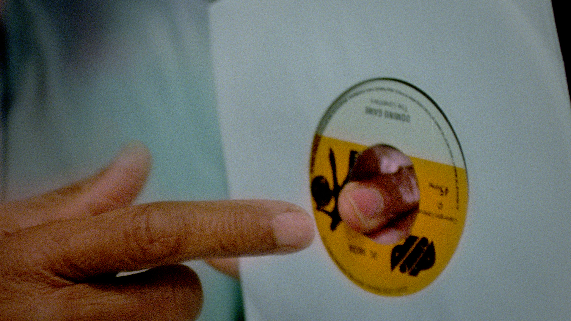 Two hands hold a record, two index fingers almost meeting through the hole in the centre.
