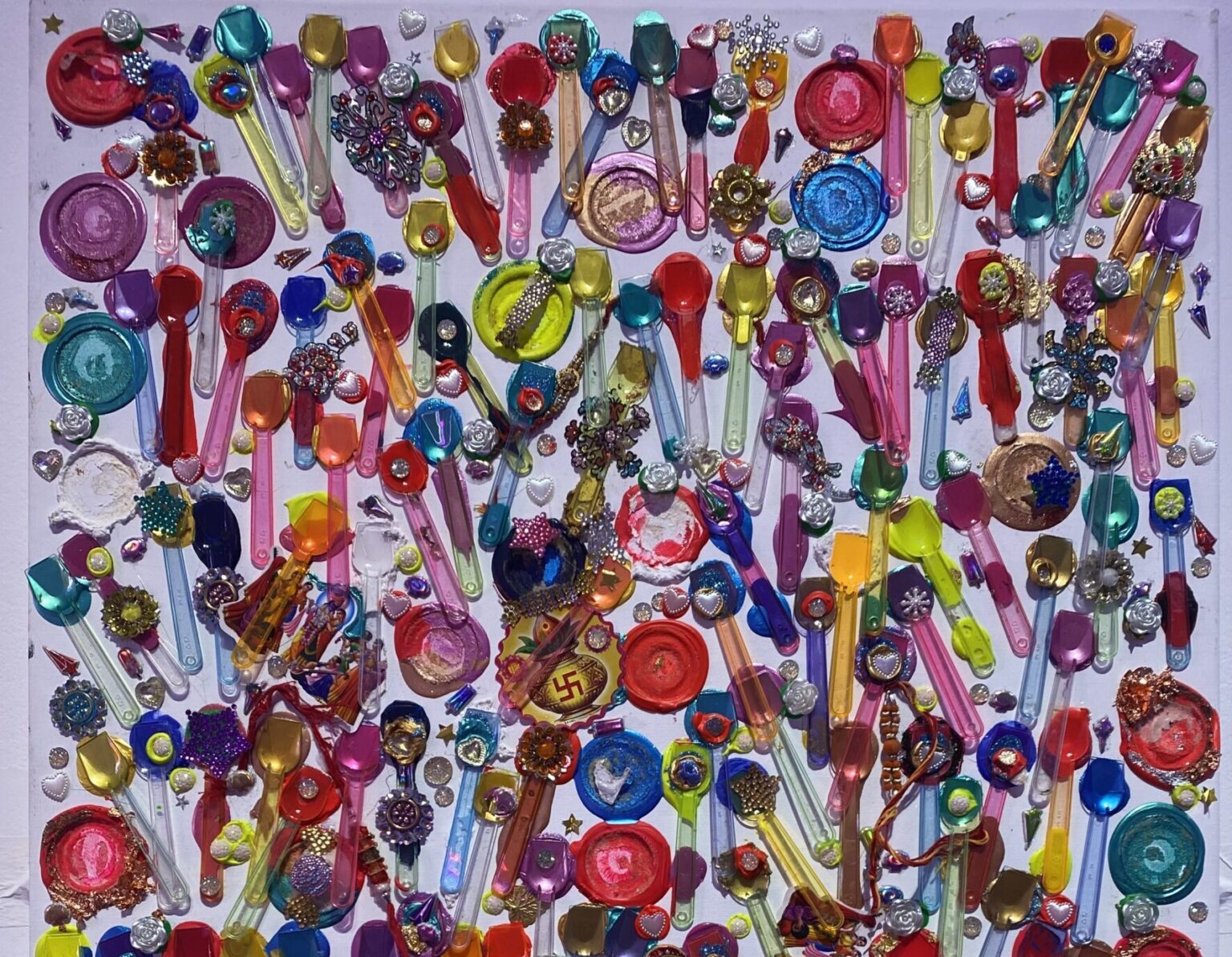 a collage made from brightly coloured ice cream spoons