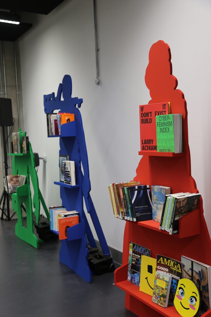 Three book shelves placed in a row: one coloured green, one blue, one red
