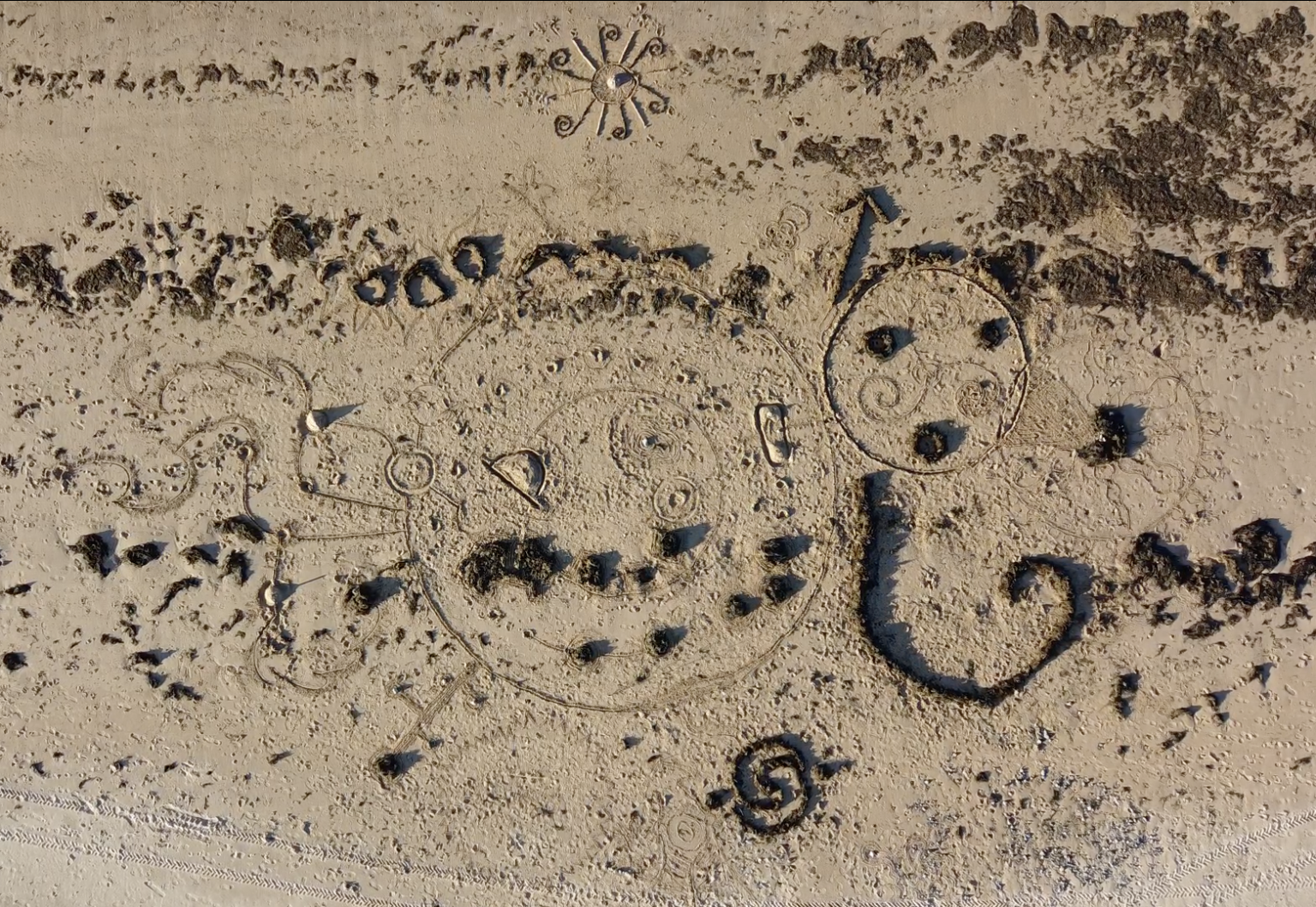 A bird's eye view of circular drawings in the sand