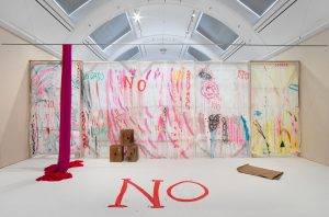 Gallery installation shot. Sheets fixed to large stretchers are painted with squiggly marks, bright colours and words such as 'No' or '16 days'