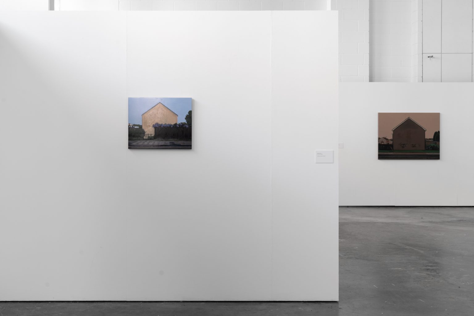 Two paintings on white walls, one in the foreground, one behind.