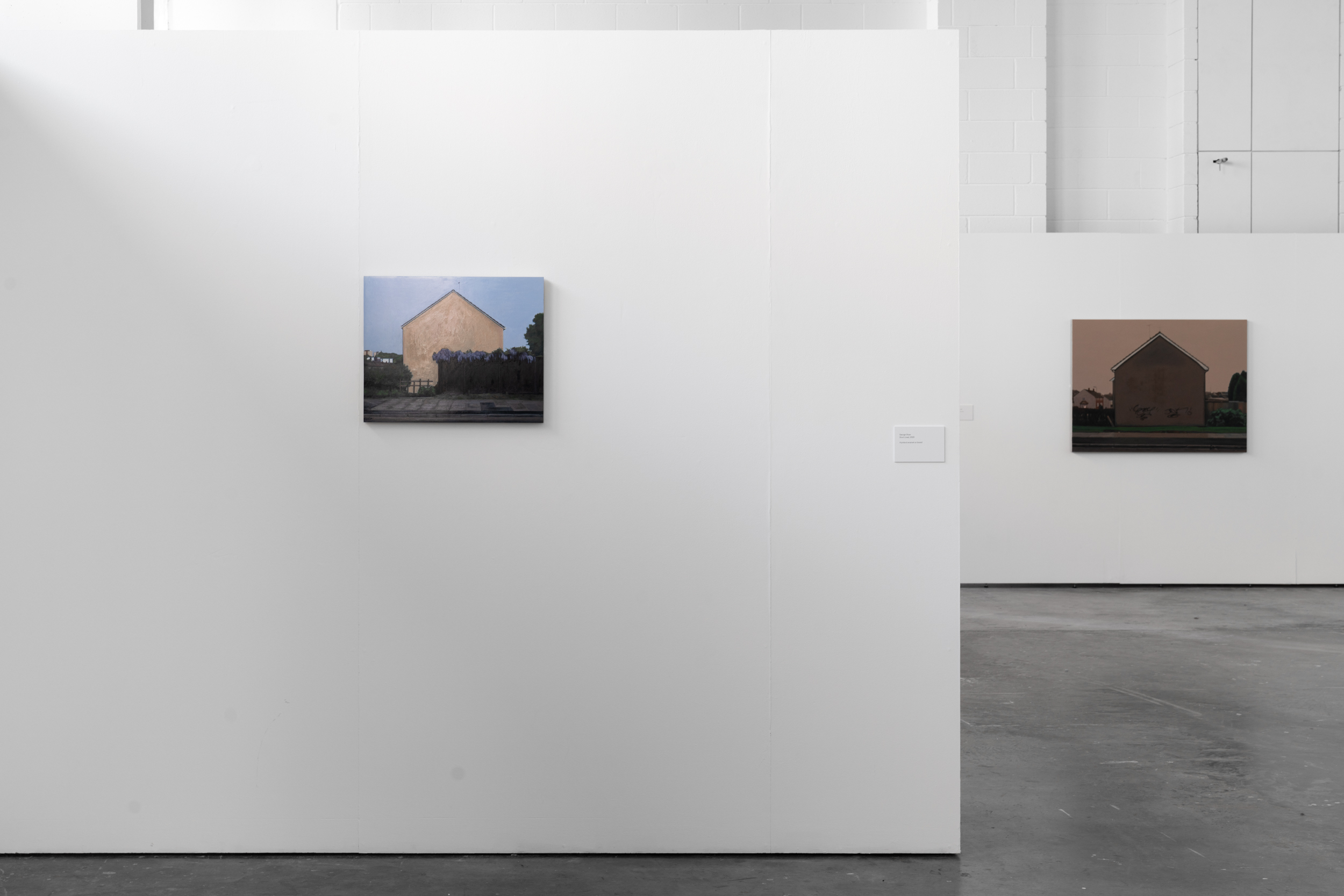 Two paintings on white walls, one in the foreground, one behind.