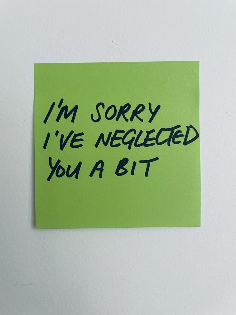 A green post-it note with the title text handwritten in black capital letters