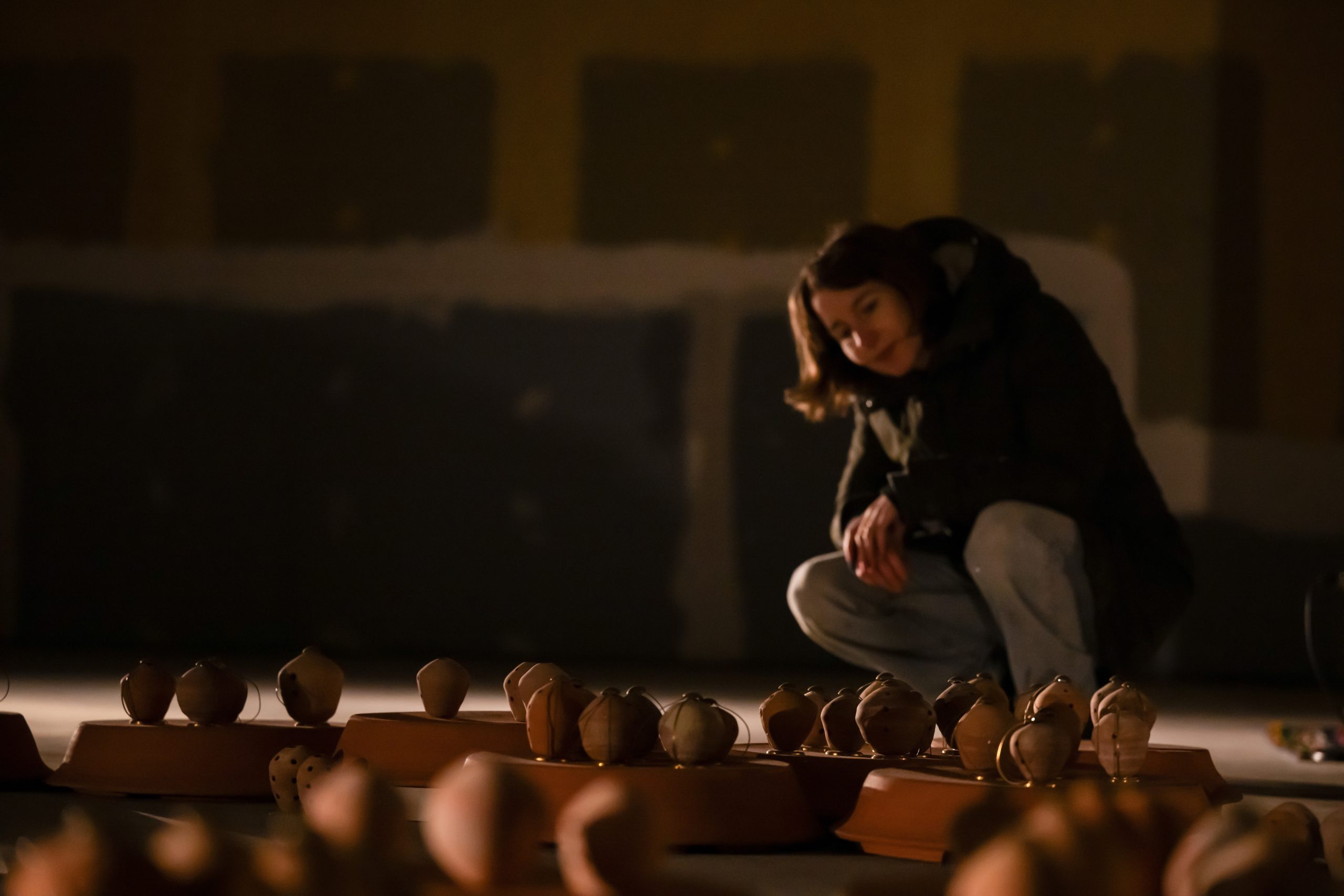 A viewer crouches down to look at the low lit borindos