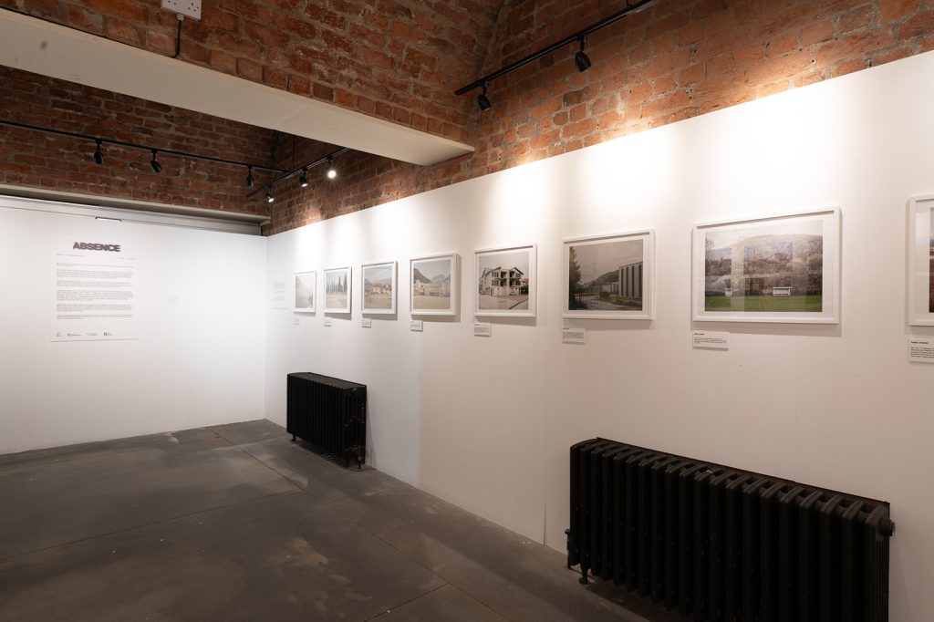 Installation shot. White walled gallery with a series of framed  hung a eye level.