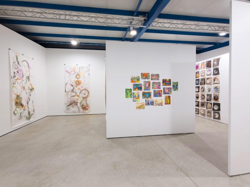 Many walls intersecting the space with small multicoloured drawings on them