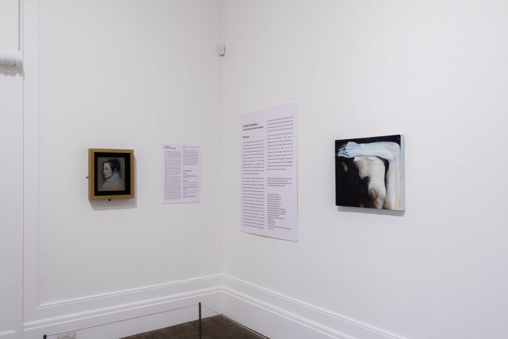 Two very small paintings, on the left a white woman in profile in a ruff, and on the right a more abstract image, perhaps a closeup of a white person's torso with a blue tinted arm wrapping around at a right angle