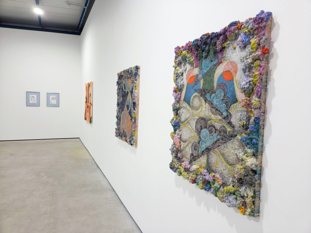 Two very thick impasto paintings of multicolours and swirling shapes, the paint so thick it looks tufted like wool