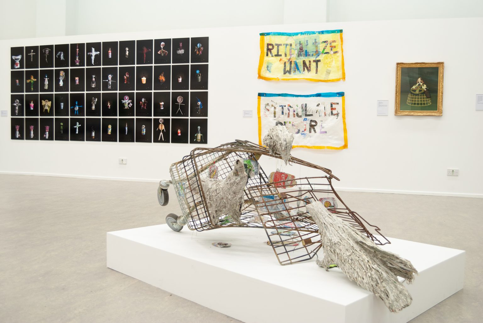 A squashed rusty shopping trolley with paper crows sitting on it