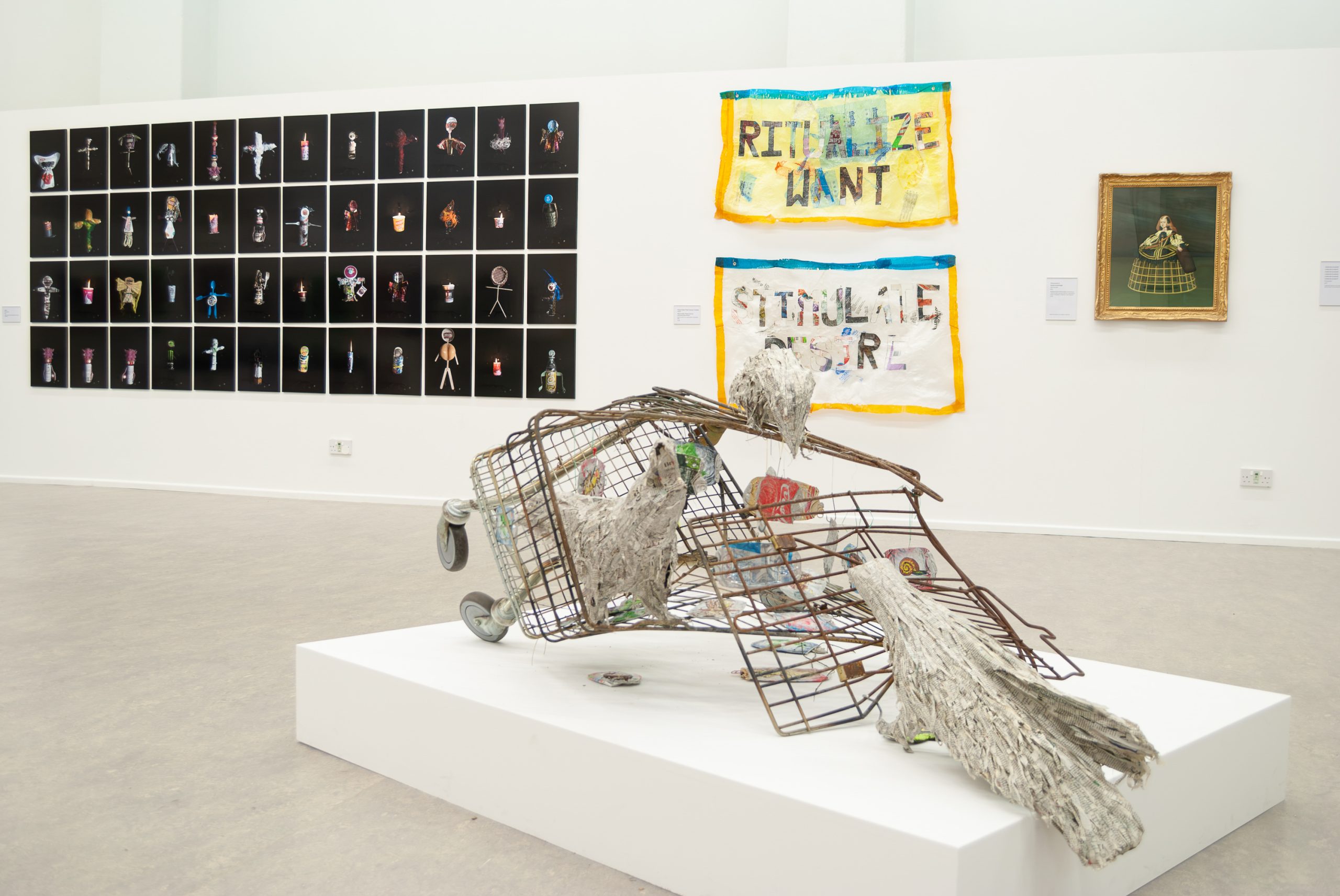 A squashed rusty shopping trolley with paper crows sitting on it