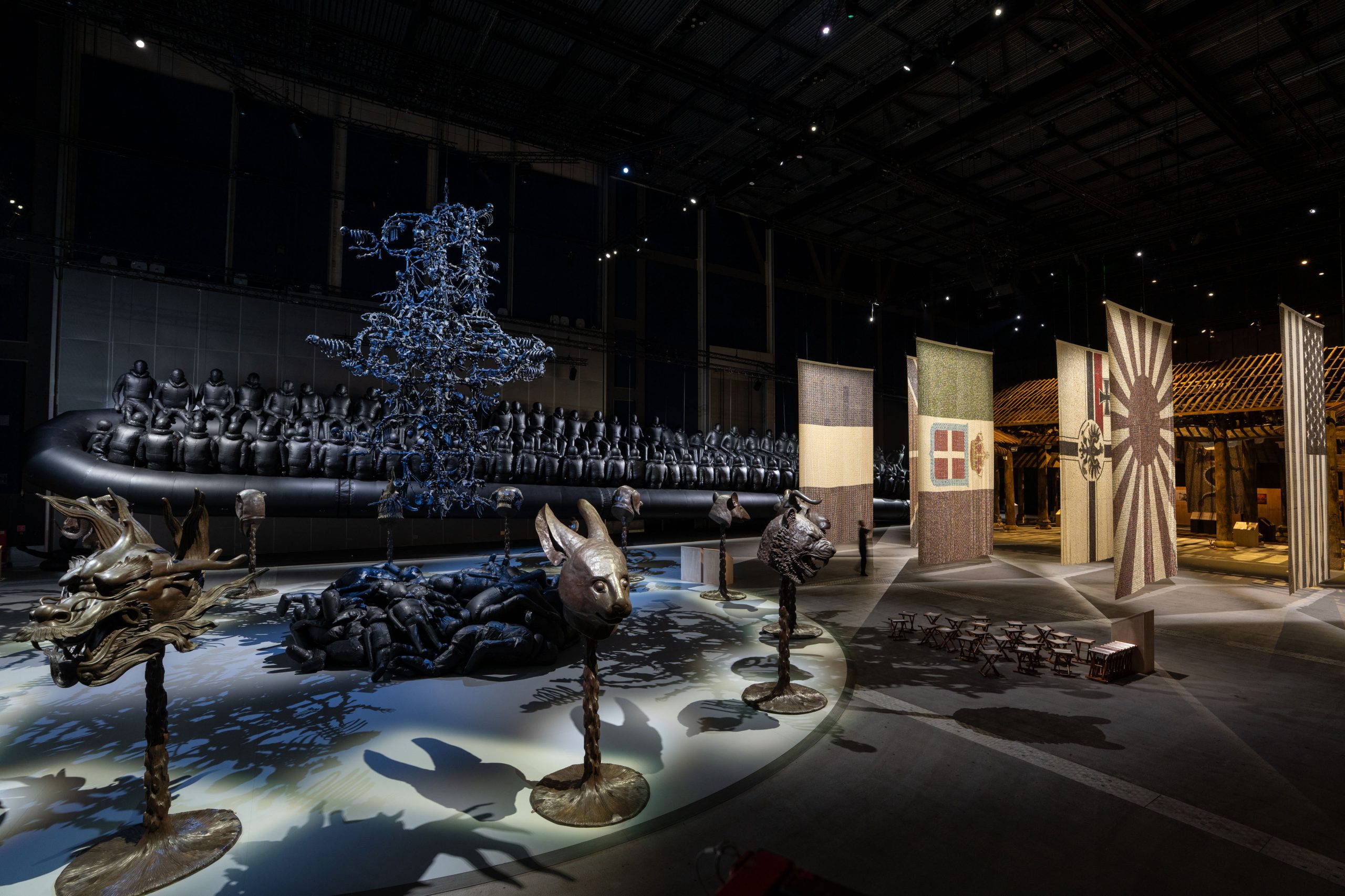 A view of the gallery with the zodiac heads in the foreground and the refugee boat behind