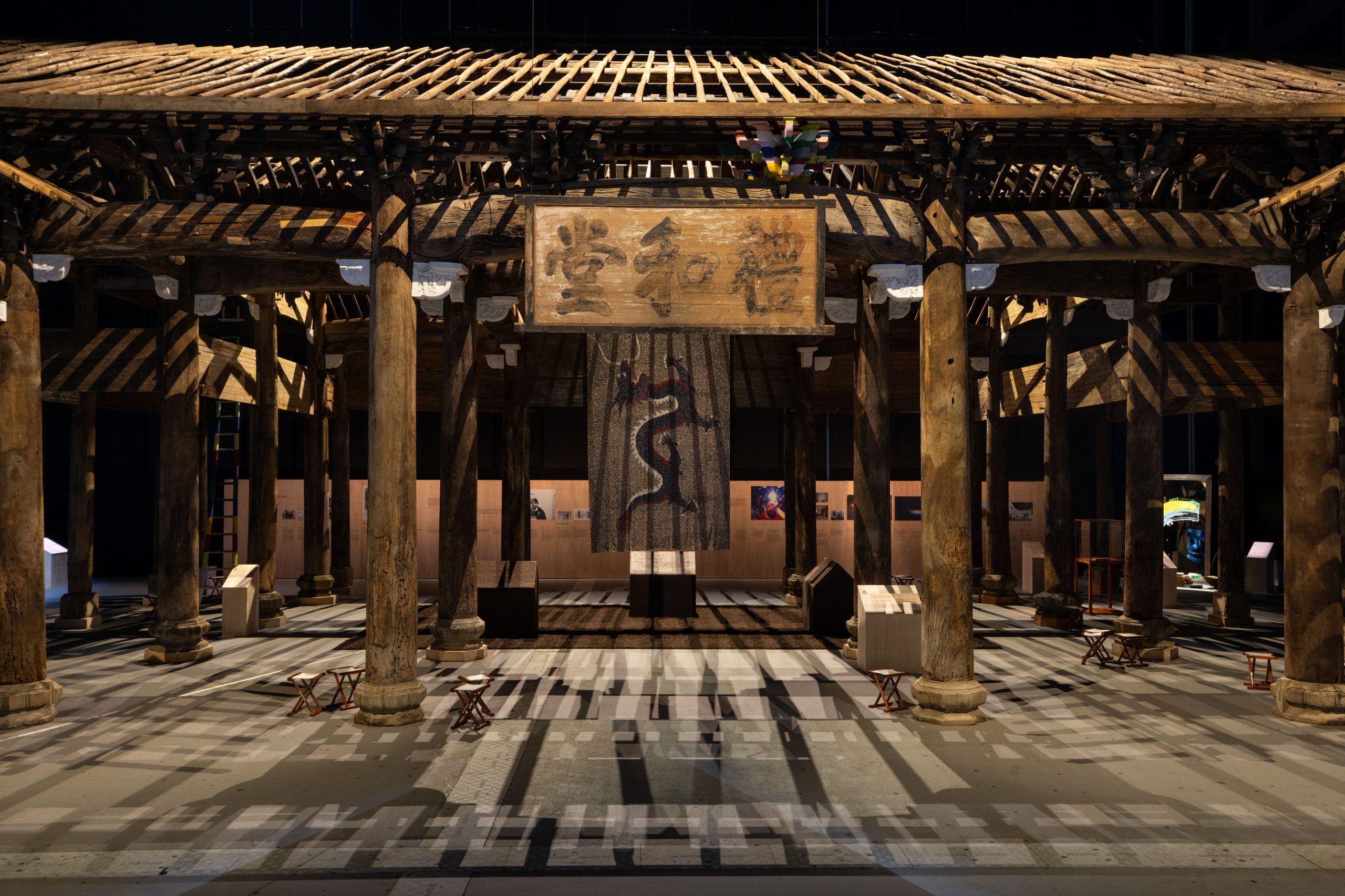 The temple face on with light filtering through the bare beams of the roof creating criss crossed shadows across the floor