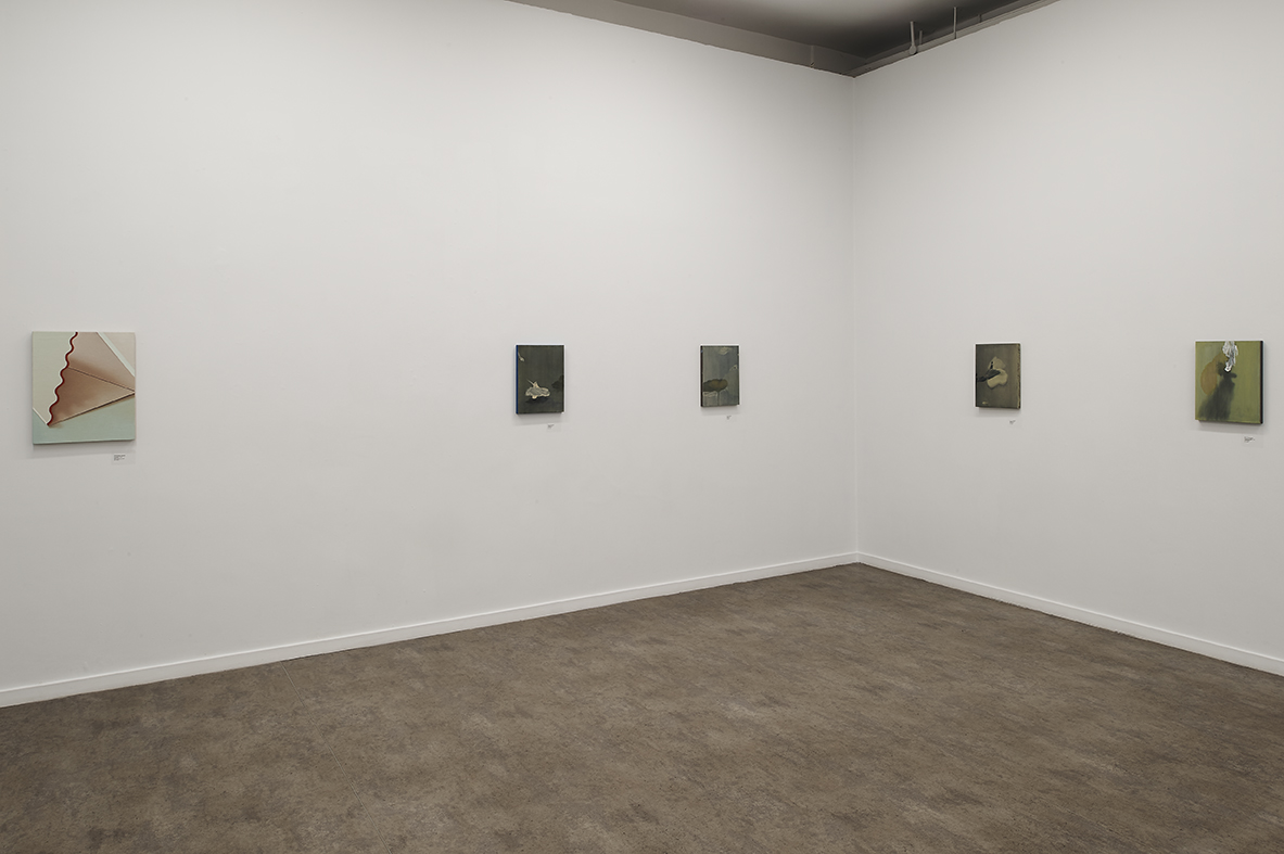 The corner of a white walled space with five very small, almost square rectangular canvases hung at eye level in a horizontal line